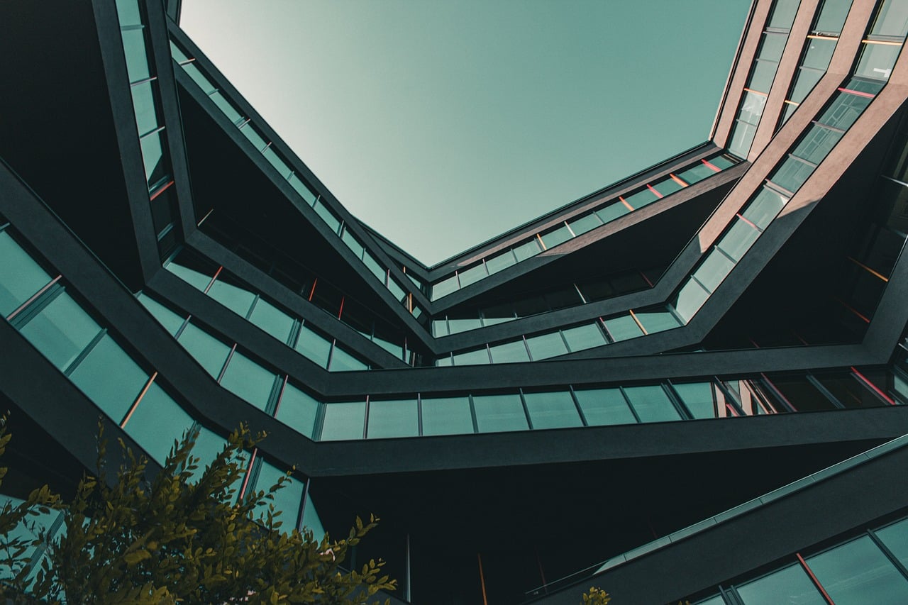 A low-angle view of a modern office building with geometric architecture and glass windows.