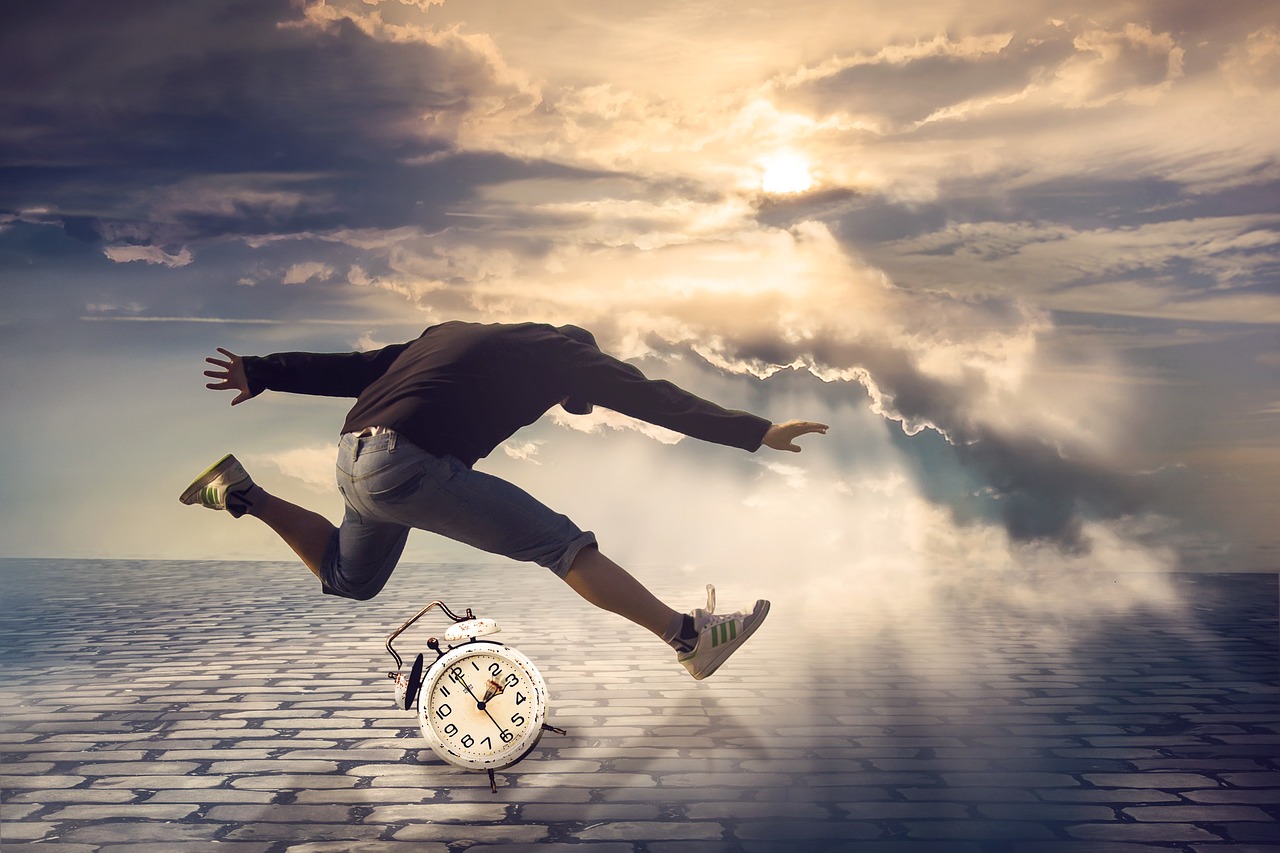 A person jumping over an alarm clock against a cloudy sky.