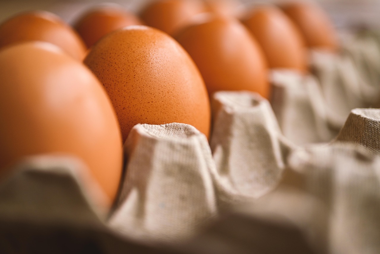 A close-up of brown eggs in a cardboard carton.