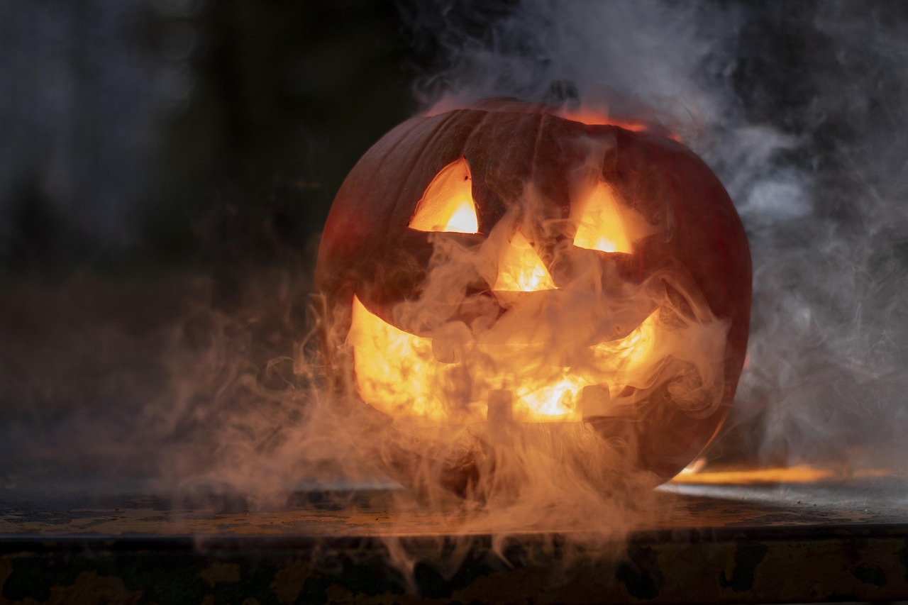 A carved jack-o'-lantern glowing from within with smoke swirling around it.