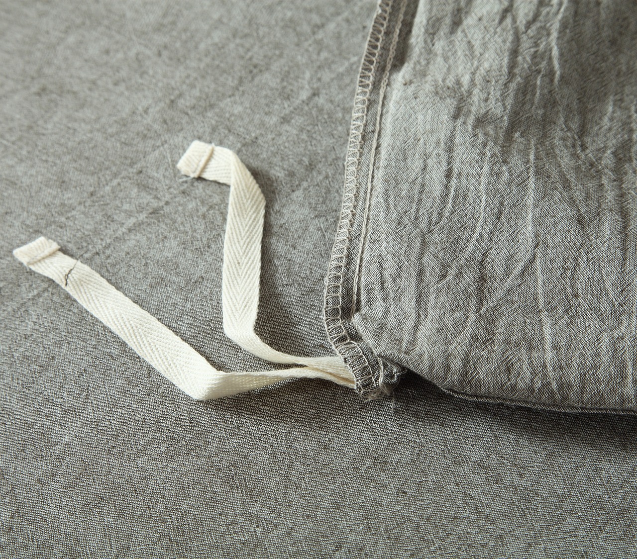 A close-up of a textured fabric item with ties, representing household textiles.