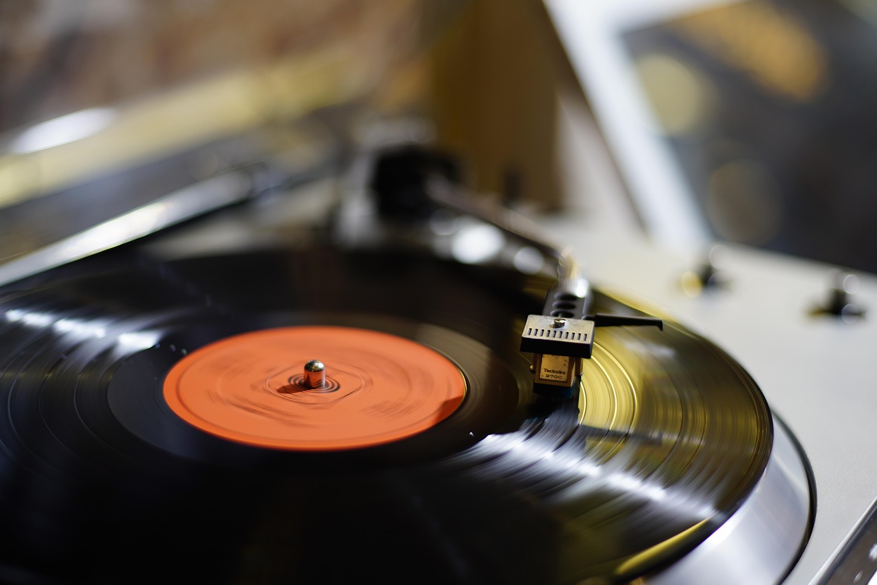 A close-up of a vinyl record spinning on a turntable, representing music and songs.