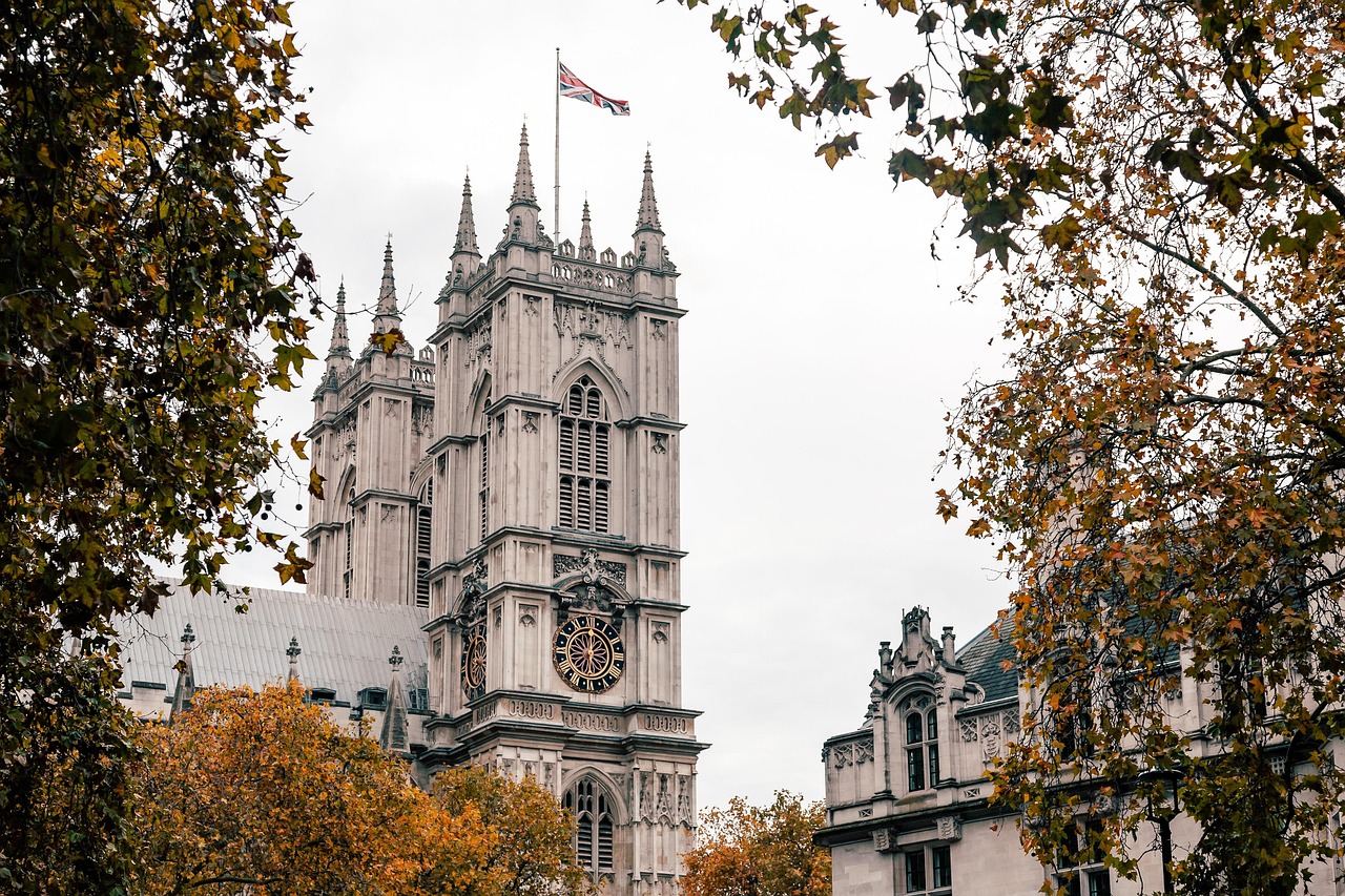 A view of the historic Westminster Abbey building with autumn trees framing the shot.
