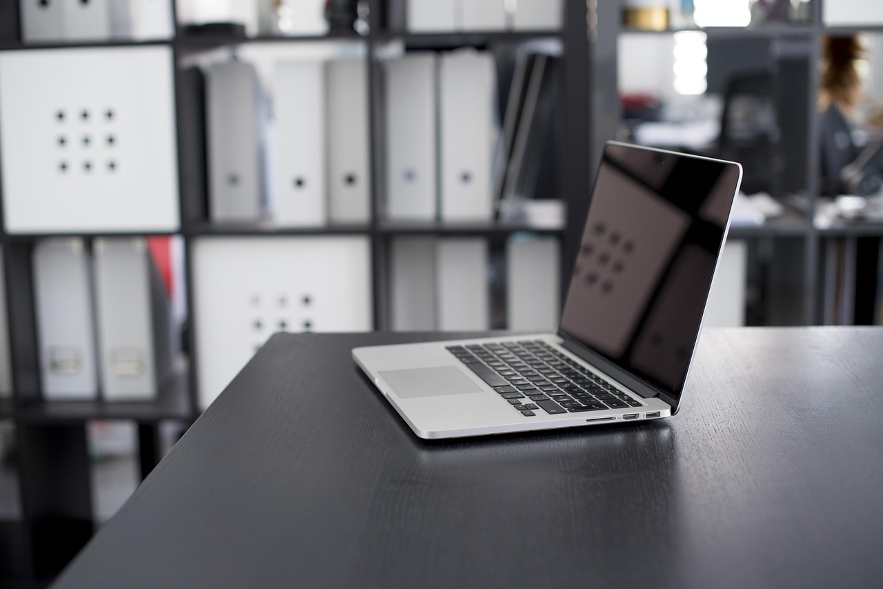 A laptop computer sitting on a desk in an office setting.