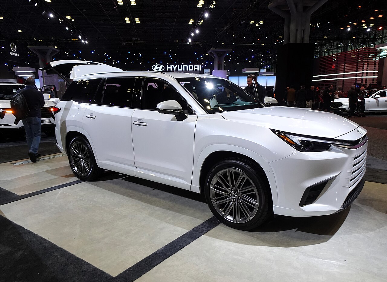 A white Lexus TX 550h+ displayed at an auto show.