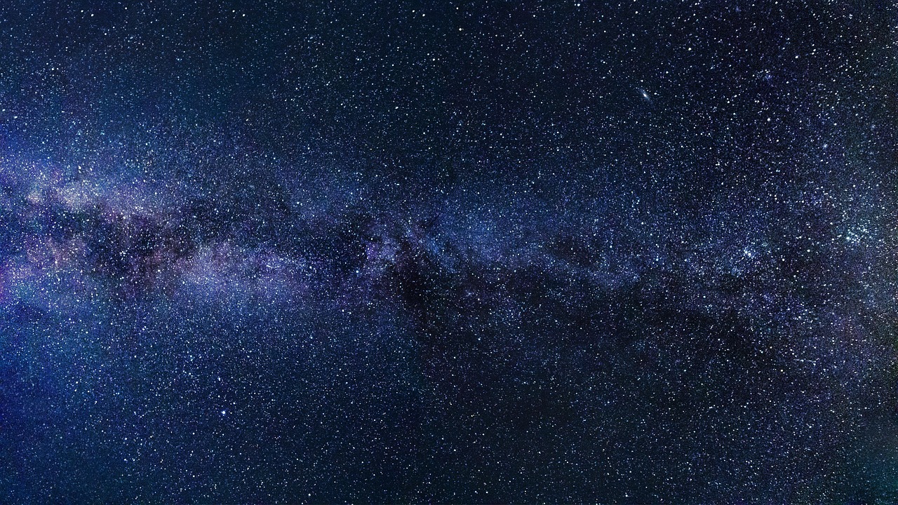 A vibrant, detailed view of the Milky Way galaxy stretching across a dark night sky filled with countless stars.