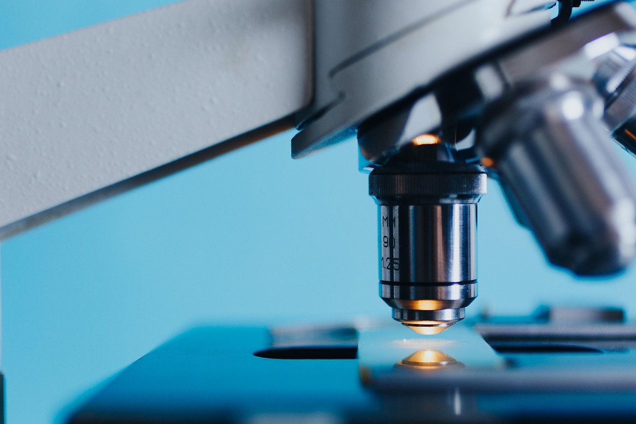 A close-up view of a laboratory microscope lens focused on a slide, representing scientific research.