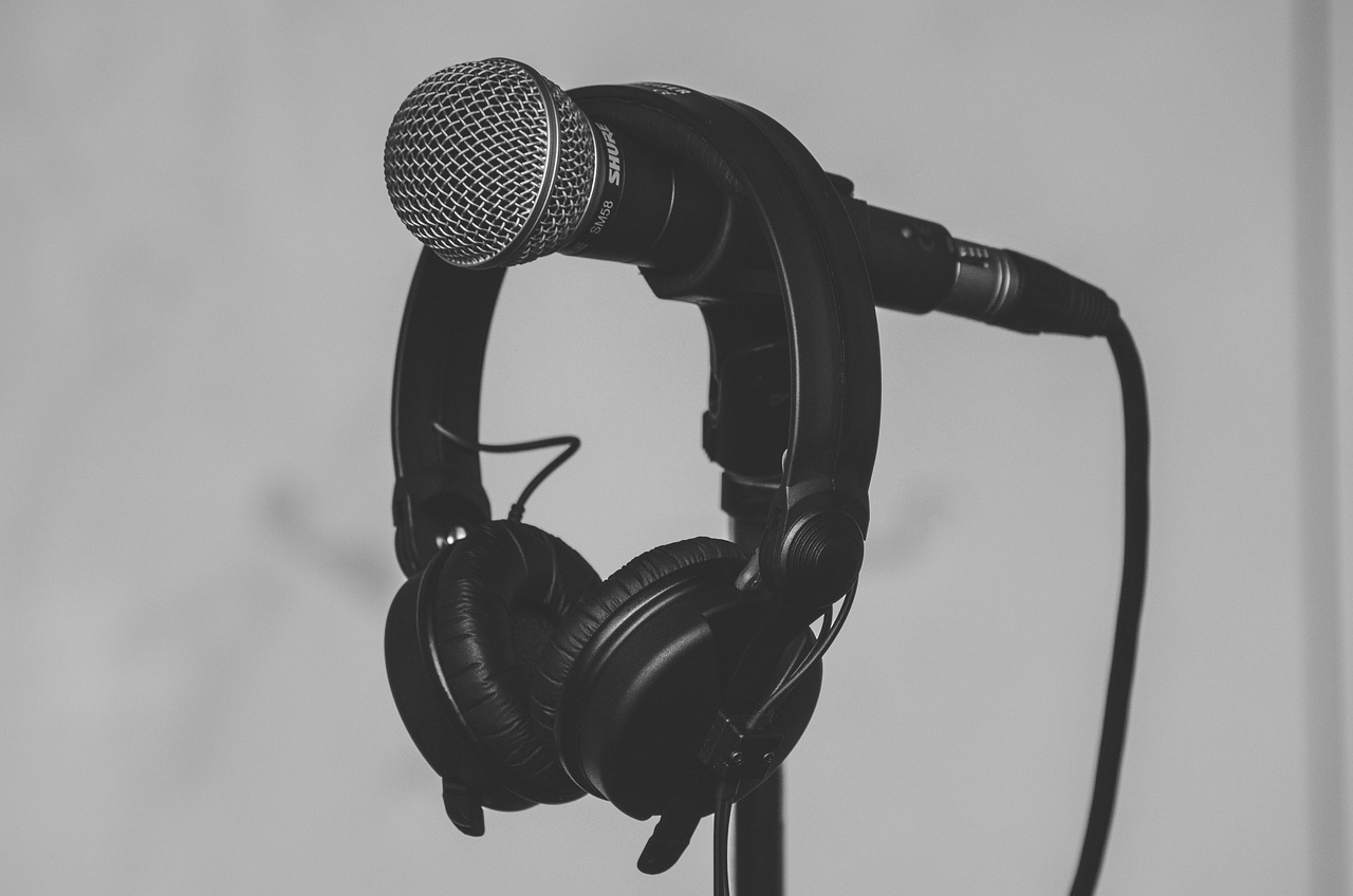 A professional microphone and headphones on a stand, representing music recording.